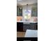 Sunlit kitchen boasts gray cabinets, a farmhouse sink, and a view to the backyard at 24841 Pine Hl, Leesburg, FL 34748
