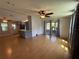 Open living room area connecting to the kitchen, with wood-look floors and ceiling fans at 24841 Pine Hl, Leesburg, FL 34748