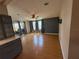 Open living room area featuring wood-look floors and access to the sunroom at 24841 Pine Hl, Leesburg, FL 34748