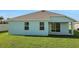 Large grassy backyard featuring a covered patio and well-maintained lawn at 2860 Supermarine Rd, Tavares, FL 32778