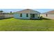 Large grassy backyard featuring a covered patio and well-maintained lawn at 2860 Supermarine Rd, Tavares, FL 32778