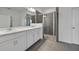 Bathroom featuring double sinks, shower with glass doors and gray tile at 2860 Supermarine Rd, Tavares, FL 32778