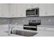 Close up of the kitchen featuring stainless steel appliances and a light gray subway tile backsplash at 2860 Supermarine Rd, Tavares, FL 32778