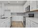 Spacious kitchen with white cabinetry, modern appliances, and a gray subway tile backsplash at 2860 Supermarine Rd, Tavares, FL 32778