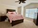 Charming bedroom showcasing a dark wooden frame with pink bedding and decor at 2918 Canyon Ave, The Villages, FL 32163