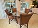Cozy dining area with a glass-topped table and wicker chairs next to a large window at 2918 Canyon Ave, The Villages, FL 32163