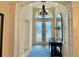 Elegant foyer with soaring ceilings, decorative chandelier, and double doors at 2918 Canyon Ave, The Villages, FL 32163