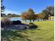 Scenic lake view with trees with fall foliage and manicured landscaping at 2918 Canyon Ave, The Villages, FL 32163