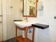 Bathroom sink with modern fixtures, wooden vanity, and floating shelves at 308 Sunnyside Dr, Leesburg, FL 34748