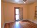 Bedroom featuring an exterior door, neutral wall paint, hardwood floors, and built-in shelving at 308 Sunnyside Dr, Leesburg, FL 34748