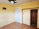 Bedroom with yellow walls, ceiling fan, wood-look floors and large sliding closet at 308 Sunnyside Dr, Leesburg, FL 34748