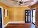 Bright bedroom with hardwood floors, ceiling fan, and a unique blue door at 308 Sunnyside Dr, Leesburg, FL 34748