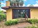Exterior of home showing sliding glass doors to deck with tropical landscaping at 308 Sunnyside Dr, Leesburg, FL 34748
