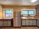Kitchen featuring stainless steel refrigerator, mosaic tile backsplash, and rustic wood floors at 308 Sunnyside Dr, Leesburg, FL 34748