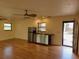 Living area featuring a kitchenette, wood floors, and natural light from large windows at 308 Sunnyside Dr, Leesburg, FL 34748