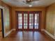 Cozy room featuring French doors with wood floors, ceiling fan, and natural light at 308 Sunnyside Dr, Leesburg, FL 34748