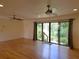 Open living room with wood floors, ceiling fan, and sliding glass doors to the backyard at 308 Sunnyside Dr, Leesburg, FL 34748
