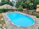 Large in-ground pool with brick surround and black metal fencing at 308 Sunnyside Dr, Leesburg, FL 34748
