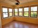 Bright sunroom featuring multiple windows with outdoor views and wood-look flooring at 308 Sunnyside Dr, Leesburg, FL 34748