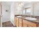 Bathroom featuring double sinks with warm cabinetry, framed mirror and a glass enclosed shower at 3118 Sweetgum St, The Villages, FL 32163