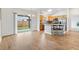Open-concept dining area with wood floors, sliding doors, and a kitchen bar with seating at 3118 Sweetgum St, The Villages, FL 32163