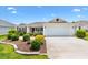 Charming single-story home with well-manicured landscaping and a two-car garage on a sunny day at 3118 Sweetgum St, The Villages, FL 32163