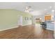 Bright living room with wood floors, adjacent to the kitchen, dining area, and sliding glass door at 3118 Sweetgum St, The Villages, FL 32163