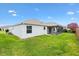 Rear view of a well-maintained home featuring a screened-in lanai and lush green lawn, perfect for outdoor living at 3118 Sweetgum St, The Villages, FL 32163