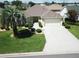 Aerial front view of a well-maintained home with an expansive driveway and manicured landscaping at 3177 Williams Rd, The Villages, FL 32162