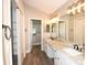 Bathroom featuring dual sinks, granite countertop, vanity lights, and spacious closet at 3177 Williams Rd, The Villages, FL 32162