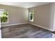 Bedroom with new luxury vinyl plank flooring, fresh paint, crown molding, and two windows at 3177 Williams Rd, The Villages, FL 32162