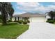 Well-maintained single-Gathering home with a paved driveway and lush landscaping at 3177 Williams Rd, The Villages, FL 32162