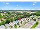 High-angle view of houses nestled in a lush, green neighborhood, with open fields in the distance at 3472 Roanoke St, The Villages, FL 32162