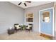 Charming entryway featuring a light blue door, wicker furniture, and neutral tile flooring at 3472 Roanoke St, The Villages, FL 32162