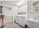 Bright laundry room featuring white washer and dryer, storage cabinets, sink, and convenient shelving at 3472 Roanoke St, The Villages, FL 32162