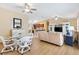 Open-concept living area with light wood floors, ceiling fans, and a comfortable seating arrangement at 3472 Roanoke St, The Villages, FL 32162