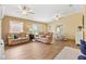 Inviting living room with wood-look flooring, comfortable seating, and a dining area at 3472 Roanoke St, The Villages, FL 32162