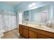 Bathroom features a double sink vanity, framed mirror, tile flooring and walk-in shower at 3731 Peaceful Valley Dr, Clermont, FL 34711