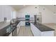 Bright, open kitchen featuring white cabinets, black countertops, and stainless steel appliances at 4817 Cr 686, Webster, FL 33597