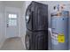 Well-lit laundry area with stacked washer/dryer and water heater in a neutral color palette at 4817 Cr 686, Webster, FL 33597