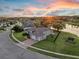 Scenic aerial view of a home with a beautiful sunset backdrop, lush trees, and a tranquil pond at 4879 Brightmour Cir, Orlando, FL 32837