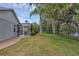 Private backyard with mature trees, tropical landscaping, and a screened-in pool at 4879 Brightmour Cir, Orlando, FL 32837
