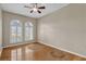 A bright bedroom with wood flooring, neutral paint, a ceiling fan, and sun-lit windows with shutters at 4879 Brightmour Cir, Orlando, FL 32837