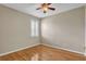 Bedroom with wood floors, ceiling fan, and window with plantation shutters at 4879 Brightmour Cir, Orlando, FL 32837