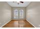 An empty bedroom with wood flooring, neutral paint, a ceiling fan, and sun-lit windows with shutters at 4879 Brightmour Cir, Orlando, FL 32837