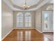 A beautiful, empty dining room with wood floors, paneled windows, tray ceiling, and a decorative light fixture at 4879 Brightmour Cir, Orlando, FL 32837