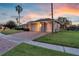 Charming home with a well-manicured lawn, brick driveway and three-car garage at dusk at 4879 Brightmour Cir, Orlando, FL 32837
