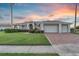 Charming single-story home with well-manicured lawn, three-car garage, and brick driveway at 4879 Brightmour Cir, Orlando, FL 32837