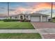 Charming single-story home with well-manicured lawn, three-car garage, and brick driveway at 4879 Brightmour Cir, Orlando, FL 32837