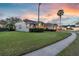 Charming home with a well-manicured lawn, brick driveway and three-car garage at dusk at 4879 Brightmour Cir, Orlando, FL 32837